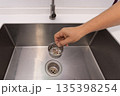 Food scraps in the basket strianer of sink 135398254