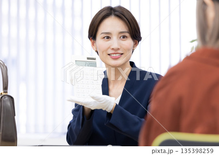 買取業者　窓口で査定をしている女性 135398259