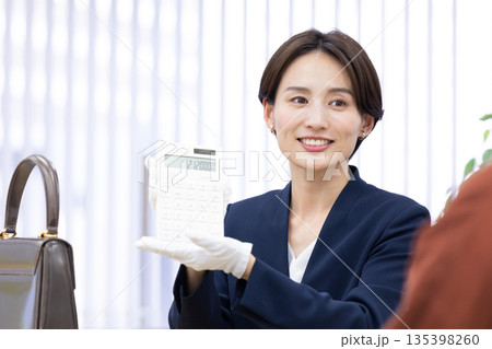 買取業者　窓口で査定をしている女性 135398260