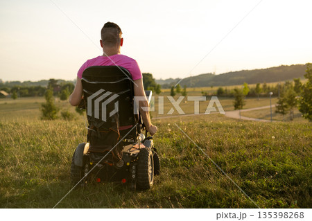 Disabled man in wheelchair enjoying life at sunset. Disabled man in wheelchair enjoying life at sunset. 135398268