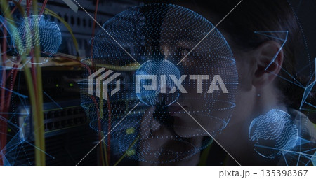 Holding handset, female technician fixing network links at rack with wireframe globes, copy space Holding handset, female technician fixing network links at rack with wireframe globes, copy space 135398367