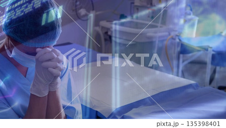 Standing surgeon in operating room monitoring holographic data beside operating table, copy space Standing surgeon in operating room monitoring holographic data beside operating table, copy space 135398401