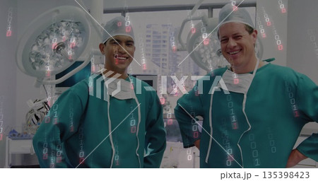 Standing two surgeons wearing green scrubs in operating room, showing LED lights and binary overlay Standing two surgeons wearing green scrubs in operating room, showing LED lights and binary overlay 135398423