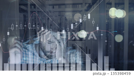 Analyzing engineer wearing plaid shirt taking notes at server room desk, with bar charts Analyzing engineer wearing plaid shirt taking notes at server room desk, with bar charts 135398459