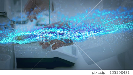 Lab tech holding steel container on digital scale at white bench, with blue data stream flowing 135398481