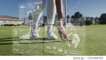Positioning golfer wearing golf attire placing golf ball at pin on putting green with holograms 135398595