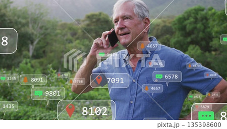 Holding smartphone man wearing denim shirt speaking at forest foothill, with floating digital icons Holding smartphone man wearing denim shirt speaking at forest foothill, with floating digital icons 135398600