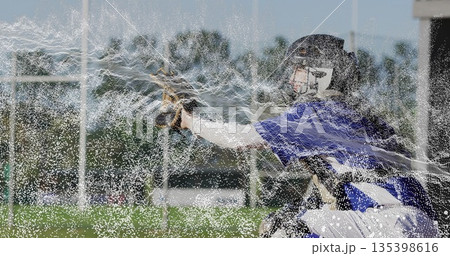 Leaning baseball catcher extending gloved hand on baseball field, with mitt and catcher's helmet 135398616