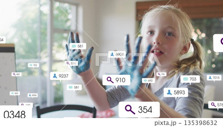 Showing girl displaying blue paint on palms in home dining area, with floating icons, copy space 135398632
