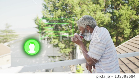 Leaning man sipping mug on balcony wearing surgical mask with green UI overlays, copy space Leaning man sipping mug on balcony wearing surgical mask with green UI overlays, copy space 135398684