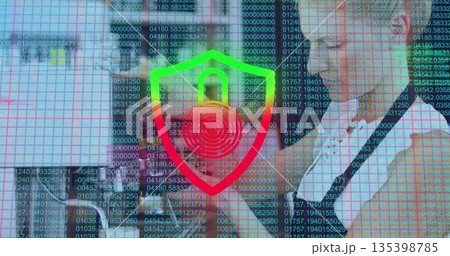 Displaying business professionals analyzing code overlay in office, with laptop and shield icon Displaying business professionals analyzing code overlay in office, with laptop and shield icon 135398785