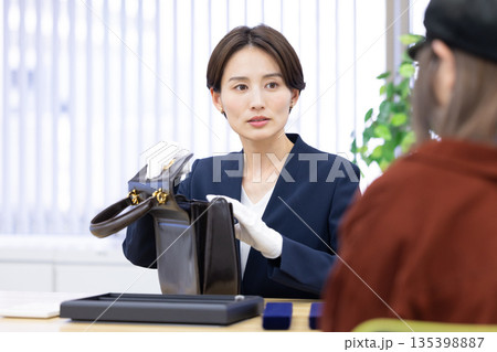 買取業者 窓口で査定をしている女性 買取業者 窓口で査定をしている女性 135398887