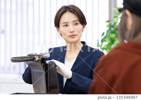 買取業者 窓口で査定をしている女性 買取業者 窓口で査定をしている女性 135398907