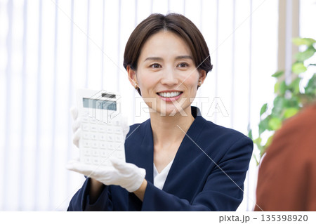 買取業者　窓口で査定をしている女性 135398920