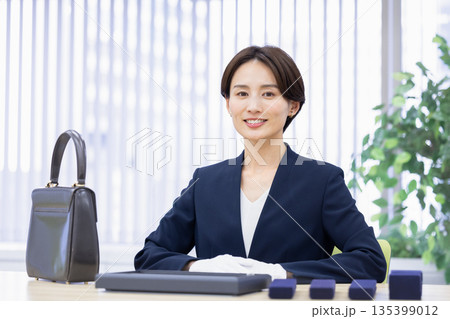 買取業者　窓口で査定をしている女性 135399012