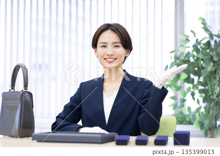 買取業者 窓口で査定をしている女性 買取業者 窓口で査定をしている女性 135399013
