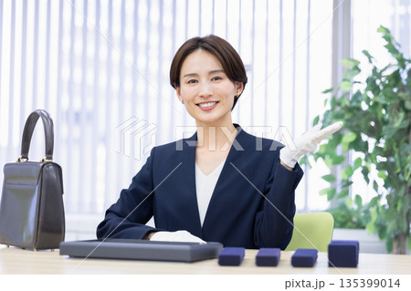 買取業者　窓口で査定をしている女性 135399014