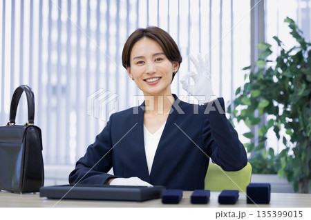 買取業者　窓口で査定をしている女性 135399015