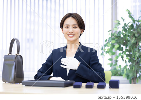 買取業者 窓口で査定をしている女性 買取業者 窓口で査定をしている女性 135399016