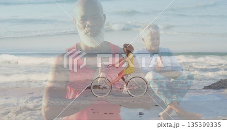 Meditating Black man wearing red tank top praying at beach, with woman riding pink bicycle Meditating Black man wearing red tank top praying at beach, with woman riding pink bicycle 135399335