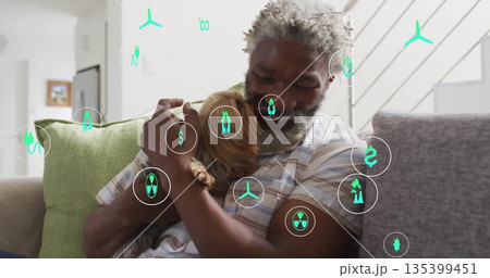 Man wearing striped shirt hugging brown dog on couch in living room, with digital energy icons Man wearing striped shirt hugging brown dog on couch in living room, with digital energy icons 135399451