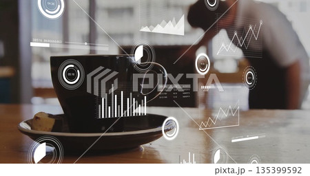 Resting black ceramic coffee cup and pastry on table at coffee shop, with floating digital charts 135399592