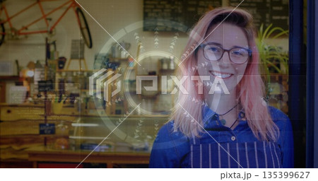 Smiling woman wearing apron standing at workshop cafe, with bicycle frame, copy space 135399627