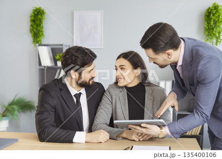 Young family couple clients meeting with bank agent, realtor or financial advisor in office Young family couple clients meeting with bank agent, realtor or financial advisor in office 135400106