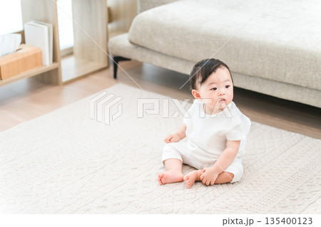 マイホームのリビングにお座りする赤ちゃん マイホームのリビングにお座りする赤ちゃん 135400123