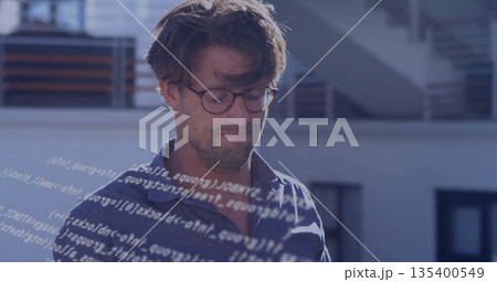 Standing developer analyzing floating code overlay on rooftop terrace, with round eyeglasses 135400549