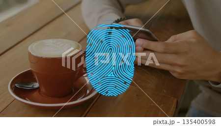 Holding smartphone Hispanic man leaning on wooden cafe table, with latte and fingerprint overlay 135400598