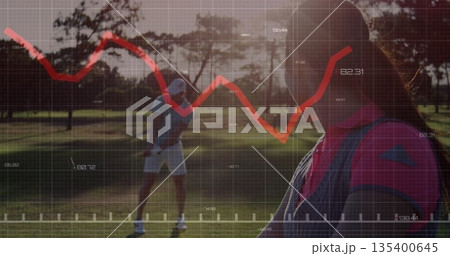 Standing female golfer holding club at golf course fairway, with line graph overlay, copy space 135400645