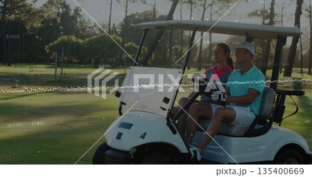 Driving man wearing golf glove steering electric golf cart on fairway, with woman in pink polo 135400669