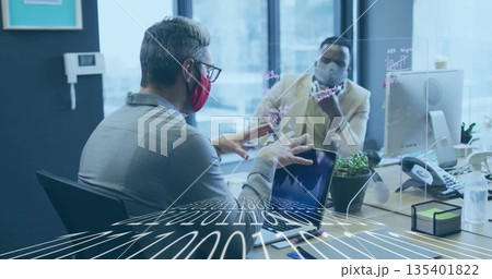 Two masked coworkers in business attire discussing data in urban office, with neon graph divider 135401822