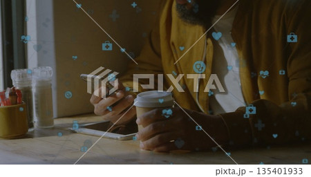 Bearded man holding smartphone and coffee cup at coffee shop table, with health icons, copy space Bearded man holding smartphone and coffee cup at coffee shop table, with health icons, copy space 135401933