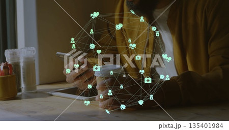 Holding coffee cup and checking smartphone, man in mustard jacket at cafe with tablet, health icons 135401984