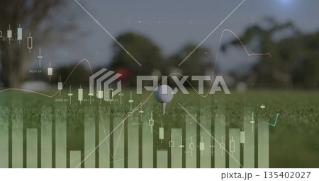 Highlighting golf ball resting on tee amid manicured grass on fairway, with financial chart overlay 135402027