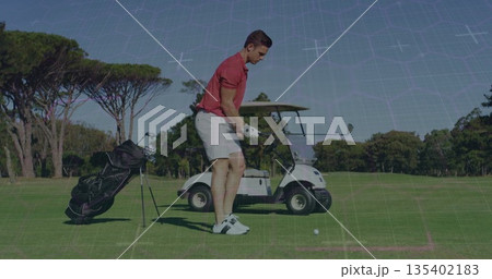 Swinging male golfer wearing red polo, white shorts on golf fairway, with golf club, ball, glove Swinging male golfer wearing red polo, white shorts on golf fairway, with golf club, ball, glove 135402183