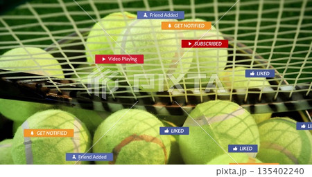 Showing neon yellow tennis balls lying under racket strings on green court, with notification icons Showing neon yellow tennis balls lying under racket strings on green court, with notification icons 135402240