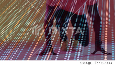 Dancers' legs stepping on stage, with red dress, black stiletto heels, tan lace-up shoes, LED grid 135402333