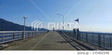 Tourists exploring scenic landscape along the dam ridge 135402506