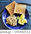 Avocado and scrambled eggs on toasted bread 135402512