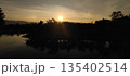 Sunset over river with mountains in the background 135402514