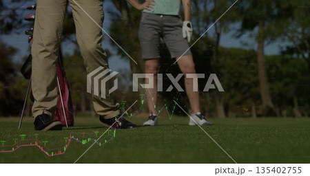 Standing couple wearing golf attire on golf course fairway, with golf bag, clubs, and glove Standing couple wearing golf attire on golf course fairway, with golf bag, clubs, and glove 135402755