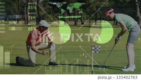 Standing female golfer aligning putter at putting green, with male kneeling, pie charts overlaying 135402763