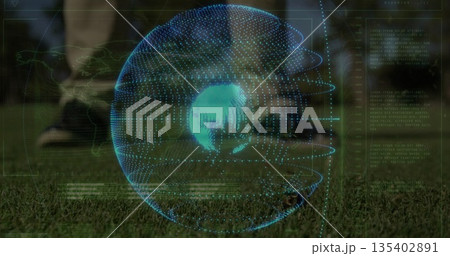 Displaying athlete in black shorts tapping soccer ball on sports field, holographic globe overlay 135402891