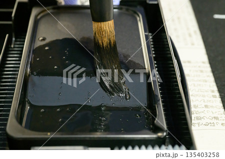 硯の海で墨をたっぷり含ませる書道の筆先 硯の海で墨をたっぷり含ませる書道の筆先 135403258