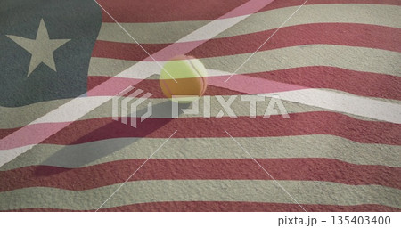 Resting yellow tennis ball beside white boundary line on red court, flag overlay, copy space 135403400