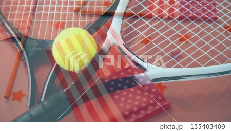 Arranging crossed tennis rackets on studio table with tennis ball, star confetti and flag overlay 135403409