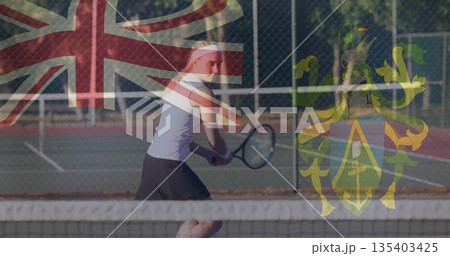 Standing tennis player gripping racket in sportswear on tennis court with Union Jack crest overlay 135403425